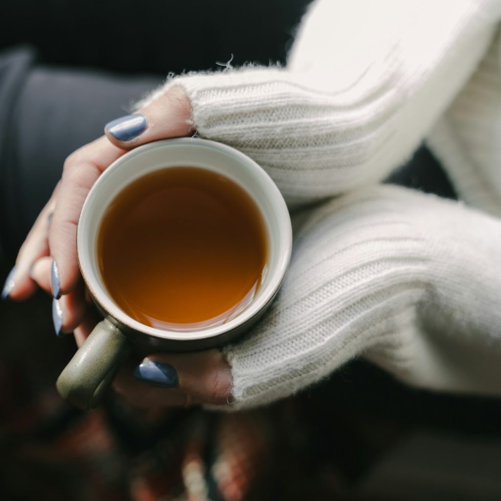 Hände halten eine warme Tasse Tee