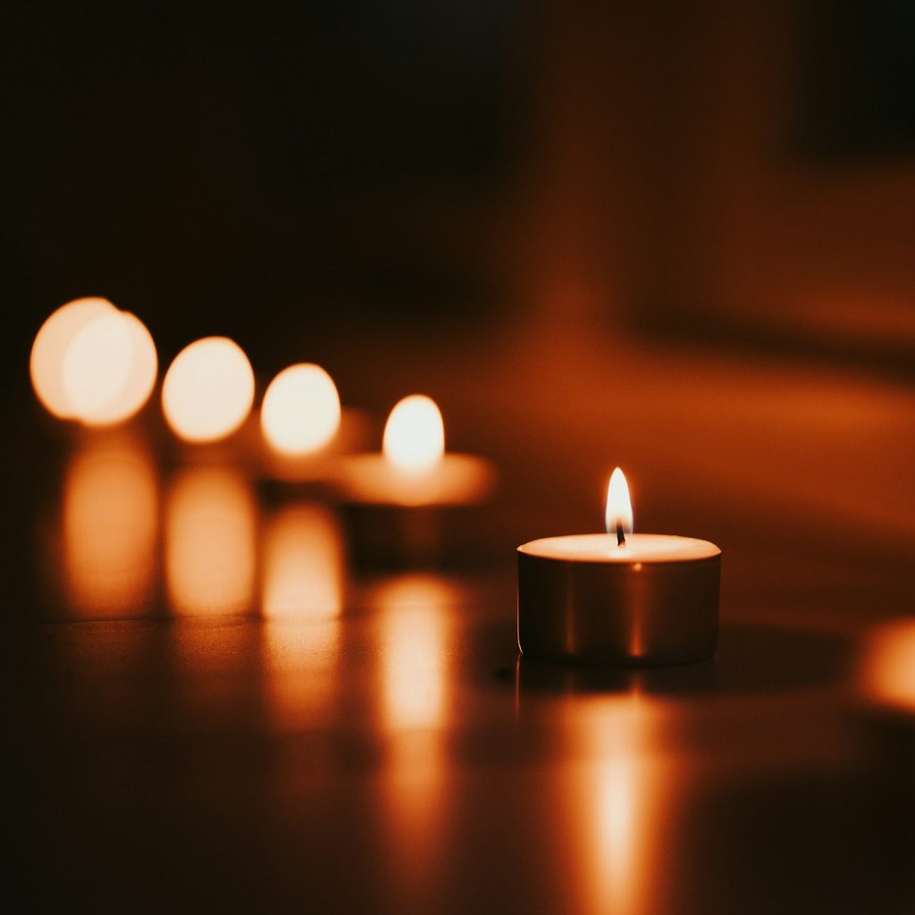Mehrere brennende Teelichter in warmem, gedämpftem Licht